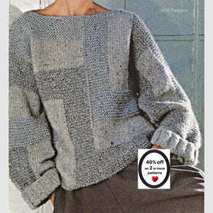 May include: A long-sleeved knit sweater featuring a patchwork design of various gray and blue-gray textured patterns. The garment has a wide boat neckline and cuffed sleeves. The text PDF Pattern is visible in the upper right corner of the image.
