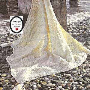 May include: A cream-coloured knitted blanket featuring intricate cable and textured stitch patterns. The blanket has a tassel at the corner and includes a white rectangular graphic with the text 40% off on 2 or more patterns and a red heart icon.