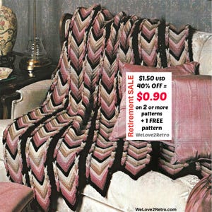 May include: A crocheted blanket with a chevron pattern in shades of black, pink, beige, and white is draped over a sofa. The blanket is paired with pink pillows. The image includes text that reads "Retirement SALE".