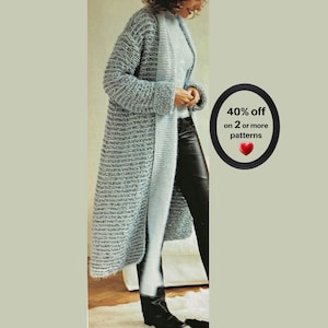 May include: A long, textured, light blue knit cardigan with long sleeves and an open front, paired with black trousers and black boots. A circular graphic on the right displays the text 40% off on 2 or more patterns with a red heart icon.