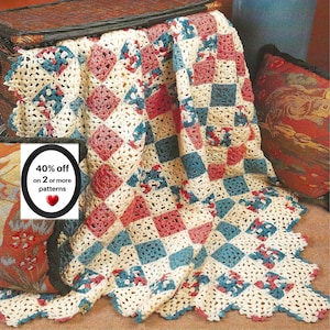 May include: A crocheted blanket featuring a repeating diamond pattern in cream, dusty rose, and teal blue yarn. The blanket has a scalloped edge and includes a white rectangular label with the black text 40% off on 2 or more patterns and a red heart.