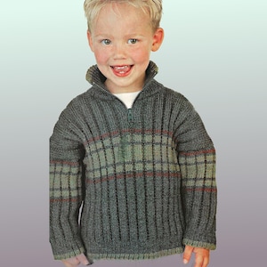Peut inclure: Un pull en tricot côtelé gris avec un col zippé. Le pull présente un motif à carreaux dans les tons de vert et de rouge. Ce pull pour enfant est un vêtement chaud et confortable.