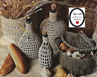 May include: A collection of beige crocheted bottle covers and baskets, including a lidded basket filled with onions and garlic, two loaves of bread, and a sign that reads 40% off on 2 or more patterns with a red heart icon.