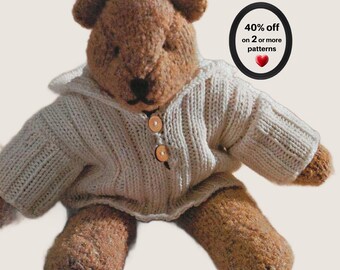 May include: A brown knitted teddy bear wearing a cream-colored ribbed sweater with a hood and two wooden buttons. A black circular graphic in the upper right corner contains the text 40% off on 2 or more patterns and a small red heart icon.