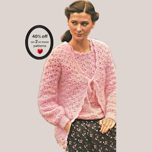 May include: A light pink crochet cardigan and matching top set featuring a delicate shell stitch pattern. The cardigan has long sleeves and a front tie closure. A black oval graphic with white text reads 40% off on 2 or more patterns.