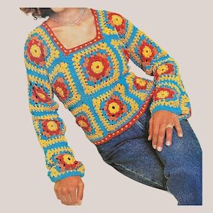 May include: A long-sleeve crochet sweater featuring a square neckline and a repeating granny square pattern. The garment is constructed from yarn in vibrant shades of bright blue, sunny yellow, and deep orange, finished with a red border trim.