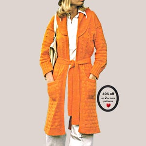 May include: A bright orange long-sleeved knit cardigan featuring a shawl collar, a tie-waist belt, and two front patch pockets. The garment is worn over a white collared shirt. A circular badge displays the text 40% off on 2 or more patterns.
