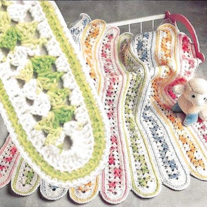 May include: A collection of colorful, crocheted baby blankets in various pastel shades. Each blanket features a unique pattern and scalloped edges. The blankets are displayed on a white crib.