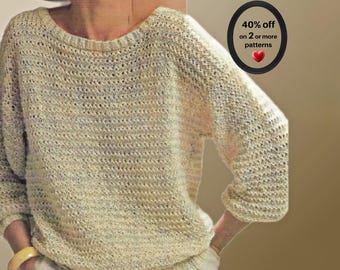 May include: A cream-colored, long-sleeved knit sweater with a wide, rounded neckline and a textured, open-stitch pattern. The garment features ribbed cuffs and a ribbed hem. A circular graphic on the right displays the text 40% off on 2 or more patterns.