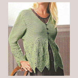 May include: A light green, open-front crochet cardigan with long sleeves and a V-neck. The cardigan features a detailed, openwork pattern along the lower edges and sleeves, and is fastened with three dark buttons. The garment is worn over a dark top.