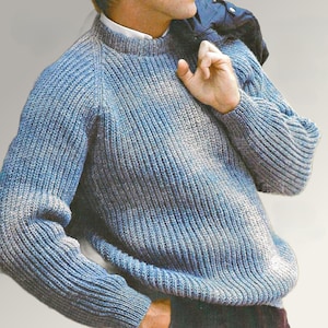 May include: A blue and gray knit sweater with a ribbed texture. The sweater has a crew neck and long sleeves. The knitwear is a blend of blue and gray yarns, creating a heathered effect. The sweater is a classic style, suitable for casual wear.