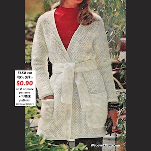May include: Cream-colored, long-sleeved cardigan with a wrap-around belt and two front pockets. The cardigan has a textured knit pattern. The model is wearing a red turtleneck underneath. The image includes the text "WeLove2Retro.com".