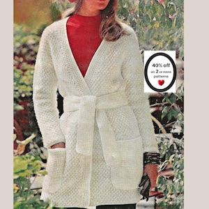 May include: A cream-colored, long-sleeved, textured knit cardigan featuring a V-neckline, a matching tie belt at the waist, and two front patch pockets. A white circular graphic displays the text 40% off on 2 or more patterns with a red heart.