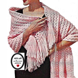 May include: A light pink crocheted shawl featuring an openwork stitch pattern and long fringe along the edges. The shawl is draped over a black garment. A circular graphic in the corner displays the text 40% off on 2 or more patterns.