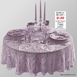 May include: A round, lavender lace tablecloth with a leaf pattern, set for a formal dinner. The table is set with plates, silverware, water glasses, and a candelabra with three candles. The text on the image says "WeLove2Retro".