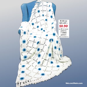 May include: A white crocheted blanket with a floral pattern in blue, draped over a blue chair. The blanket has a fringed edge and a geometric design. The text "WeLove2Retro" is visible.