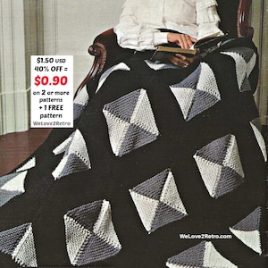 May include: A black knitted blanket featuring geometric diamond patterns in grey and white. The blanket is draped over a chair. The text "WeLove2Retro.com" is visible.
