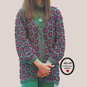 May include: A long-sleeved crochet cardigan featuring a repeating hexagonal floral pattern in shades of magenta and teal. The garment has a V-neckline, a front tie closure, and a scalloped hem. A circular badge displays the text 40% off on 2 or more patterns.