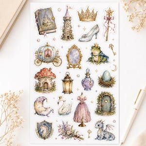 Op de afbeelding: Een stickervel met diverse fantasie-illustraties, waaronder een kasteelboek, een stenen toren, een gouden kroon, een glazen muiltje, een toverstaf, een pompoenkoets, een spiegel, een kikkerprins, een paddenstoelhuis, een lantaarn, een drankje, een ei in een nest, een maan, een zwaan, een jurk, een deur, een schild, bloemen en een draak.