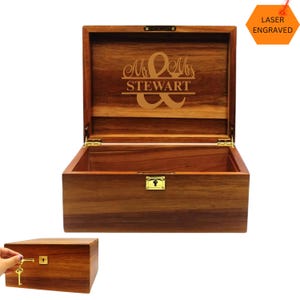 May include: A wooden box with a hinged lid and a brass lock. The lid is engraved with the words "Mr. & Mrs. STEWART" and an ampersand symbol. The box is laser engraved.
