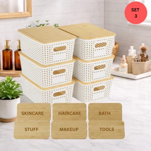 May include: A set of six white plastic storage baskets with bamboo lids. Each basket has a rectangular shape with a perforated design. Six wooden labels are included, with the following text: Skincare, Haircare, Bath, Stuff, Makeup, and Tools.