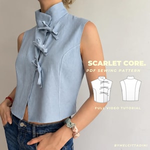 Puede incluir: Una blusa azul claro sin mangas con cuello alto y tres cierres de lazo de tela en la parte delantera. La imagen incluye una ilustración gráfica de la vista frontal y trasera de la prenda con el texto SCARLET CORE. PDF SEWING PATTERN FULL VIDEO TUTORIAL.