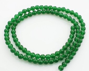 May include: A strand of green jade beads. The beads are round and smooth, and they are strung on a clear thread.