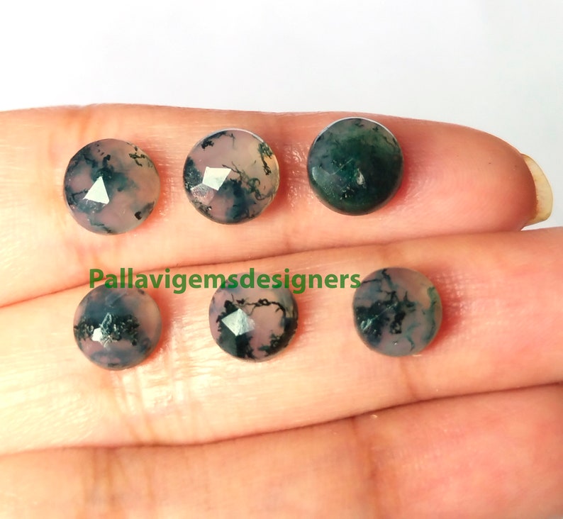 May include: Six round, faceted, green and pink agate cabochons. The stones have a mottled, cloudy appearance with dark green and light pink colors.