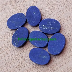 May include: Seven oval-shaped lapis lazuli cabochons, ranging in size, with a deep blue colour and flecks of gold pyrite.