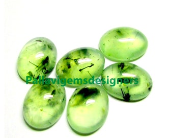 May include: Six oval-shaped green gemstones with black inclusions. The gemstones are smooth and polished.