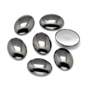 May include: Seven oval-shaped, black hematite cabochons. The cabochons are smooth and have a high polish.