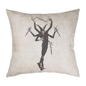 May include: A throw pillow with a black and white illustration of a jester with multiple arms holding knives. The jester has a red heart on its chest.