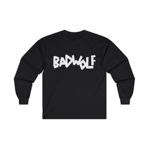 Op de afbeelding: Zwart longsleeve t-shirt met een witte afbeelding van het woord "BADWOLF" in een gestileerd lettertype.