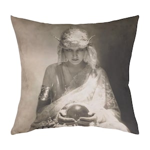 May include: A woman in a white lace dress and a crown holds a crystal ball in her hands. The image is in black and white and has a vintage feel.