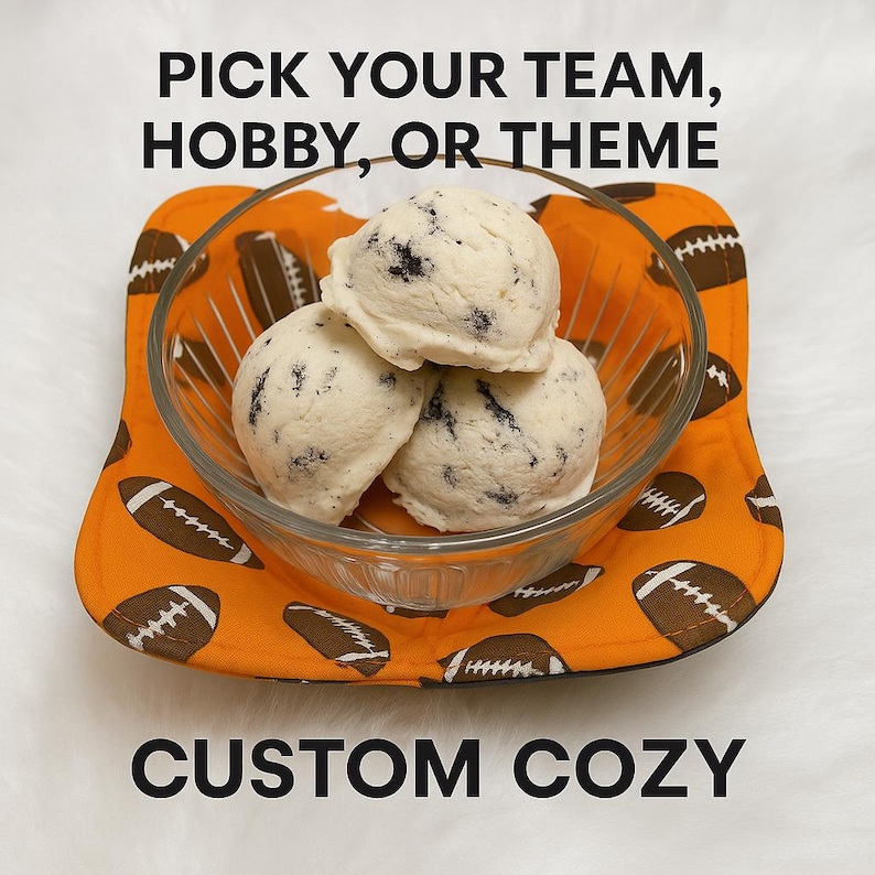 Puede incluir: Un cuenco de vidrio con tres bolas de helado de galletas y crema, sobre un posavasos naranja con estampado de f&uacute;tbol. El posavasos tiene balones de f&uacute;tbol marrones. El texto de la imagen dice "PICK YOUR TEAM, HOBBY, OR THEME" y "CUSTOM COZY."