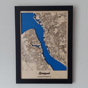 Pu&ograve; includere: Una mappa di legno di Liverpool, Regno Unito, con un'intarsio blu che rappresenta il fiume Mersey. La mappa &egrave; incorniciata in nero e ha uno sfondo in legno chiaro.