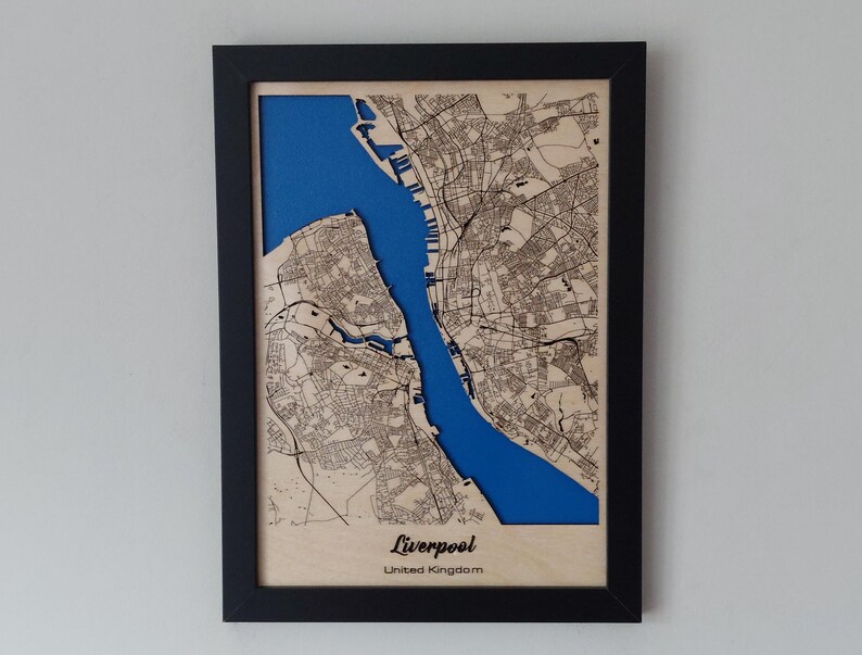 Pu&ograve; includere: Una mappa di legno di Liverpool, Regno Unito, con un'intarsio blu che rappresenta il fiume Mersey. La mappa &egrave; incorniciata in nero e ha uno sfondo in legno chiaro.