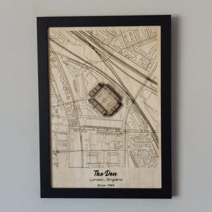 Pu&ograve; includere: Un'illustrazione in bianco e nero di uno stadio di calcio, The Den, a Londra, in Inghilterra. Lo stadio &egrave; circondato da strade ed edifici. Il testo "The Den, Londra, Inghilterra, Dal 1993" &egrave; stampato sotto lo stadio.