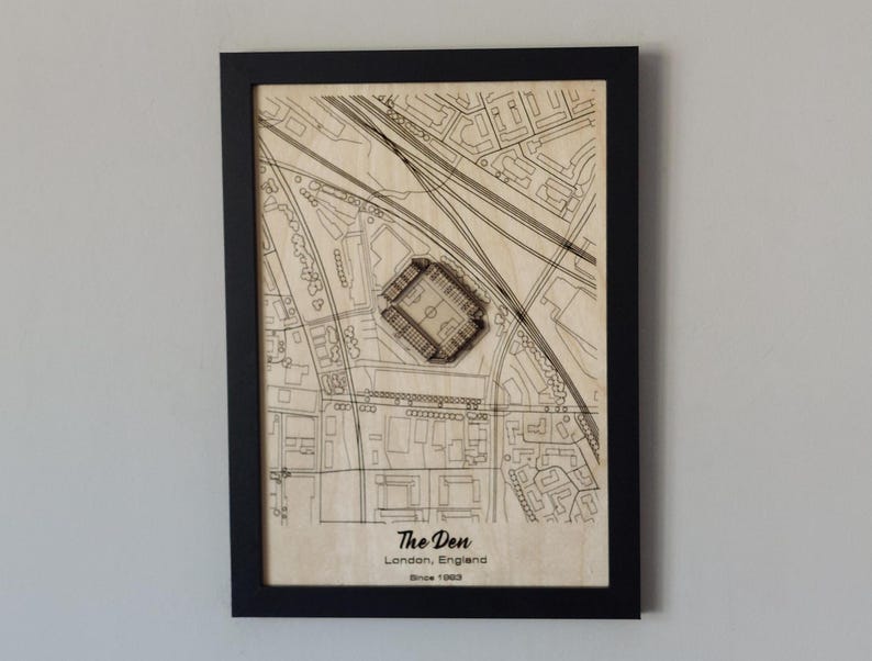 Pu&ograve; includere: Un'illustrazione in bianco e nero di uno stadio di calcio, The Den, a Londra, in Inghilterra. Lo stadio &egrave; circondato da strade ed edifici. Il testo "The Den, Londra, Inghilterra, Dal 1993" &egrave; stampato sotto lo stadio.