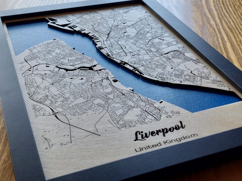 Pu&ograve; includere: Una mappa di legno di Liverpool, Regno Unito, con sfondo blu e cornice nera. La mappa &egrave; in rilievo e ha un effetto 3D.