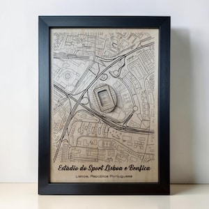May include: A framed wooden map featuring a laser-engraved street layout and a raised 3D model of the Estádio do Sport Lisboa e Benfica. The text reads Estádio do Sport Lisboa e Benfica and Lisboa, República Portuguesa in a black frame.