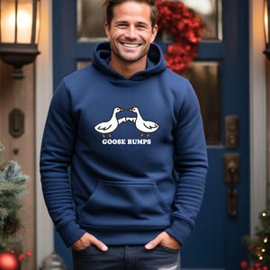 May include: A navy blue hoodie with a white graphic of two geese facing each other with the text "GOOSE BUMPS" underneath.