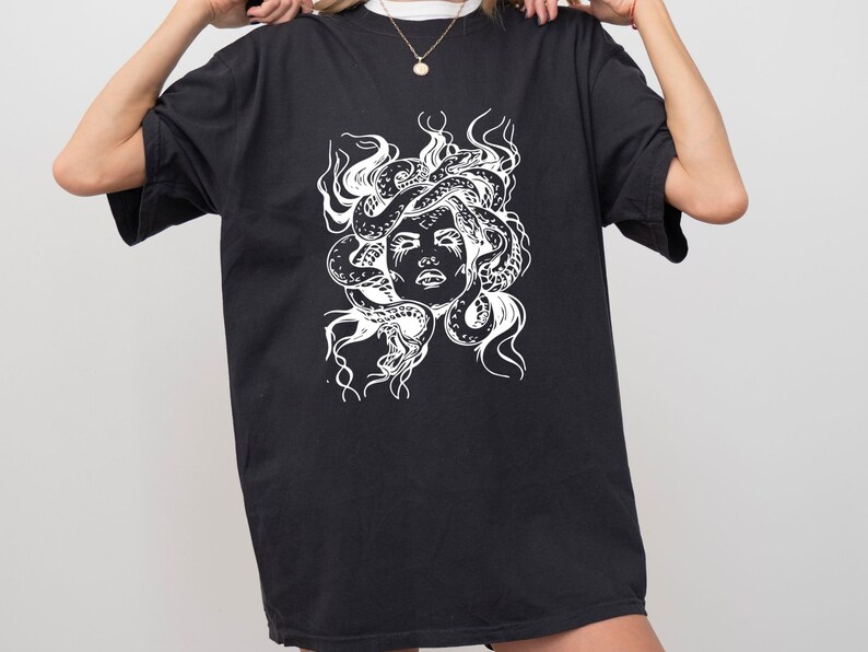 May include: Black t-shirt with a white graphic of Medusa's head with snakes.