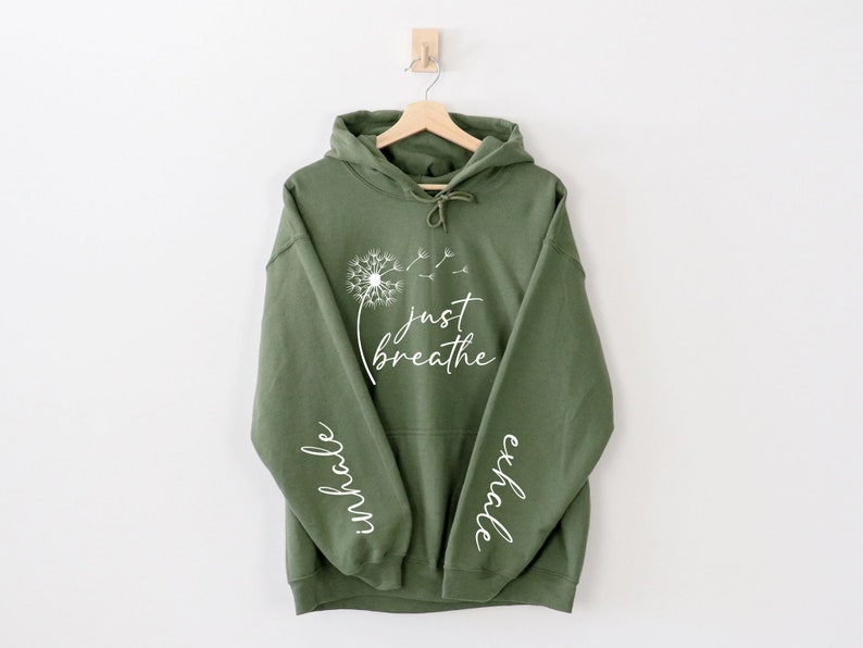 May include: A green hooded sweatshirt with the words "Just Breathe" and a dandelion graphic on the front. The words "inhale" and "exhale" are printed on the sleeves.