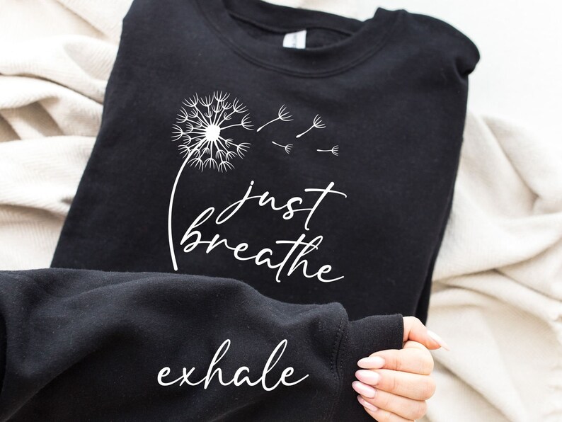 May include: Black sweatshirt with a white dandelion graphic and the text "just breathe exhale".