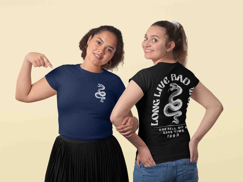 K&ouml;nnte beinhalten: Zwei Frauen tragen T-Shirts mit einem Schlangenmotiv. Das schwarze T-Shirt hat den Text "Long Live Bad" und "One hell of a good time 1993" auf der R&uuml;ckseite. Das marineblaue T-Shirt hat ein Schlangenmotiv auf der Vorderseite.