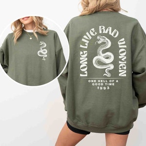 K&ouml;nnte beinhalten: Gr&uuml;ner Sweatshirt mit einem wei&szlig;en Schlangen-Motiv auf der Vorderseite und einem wei&szlig;en Schlangen-Motiv mit dem Text "Long Live Bad Women" und "One Hell of a Good Time 1993" auf der R&uuml;ckseite.