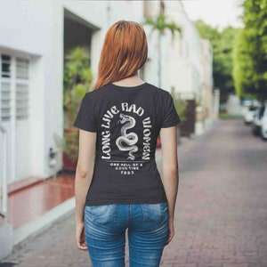 K&ouml;nnte beinhalten: Schwarzes T-Shirt mit einem wei&szlig;en Grafikdruck einer Schlange mit dem Text "Long Live Bad Women" und "One hell of a good time 1993".
