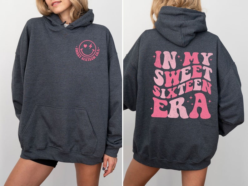 May include: A dark gray hoodie with a pink smiley face and the text "Sweet Sixteen Era" on the front and the text "In My Sweet Sixteen Era" on the back.