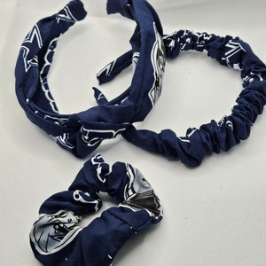 Pu&ograve; includere: Due accessori per capelli blu navy con stampa bianca. Uno &egrave; una fascia per capelli con un fiocco annodato e l'altro &egrave; un elastico per capelli.